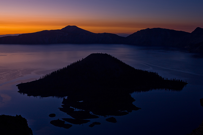 &nbsp;The blackness of Wizard Island slowly becomes outlined against the blue of Crater Lake at sunrise.