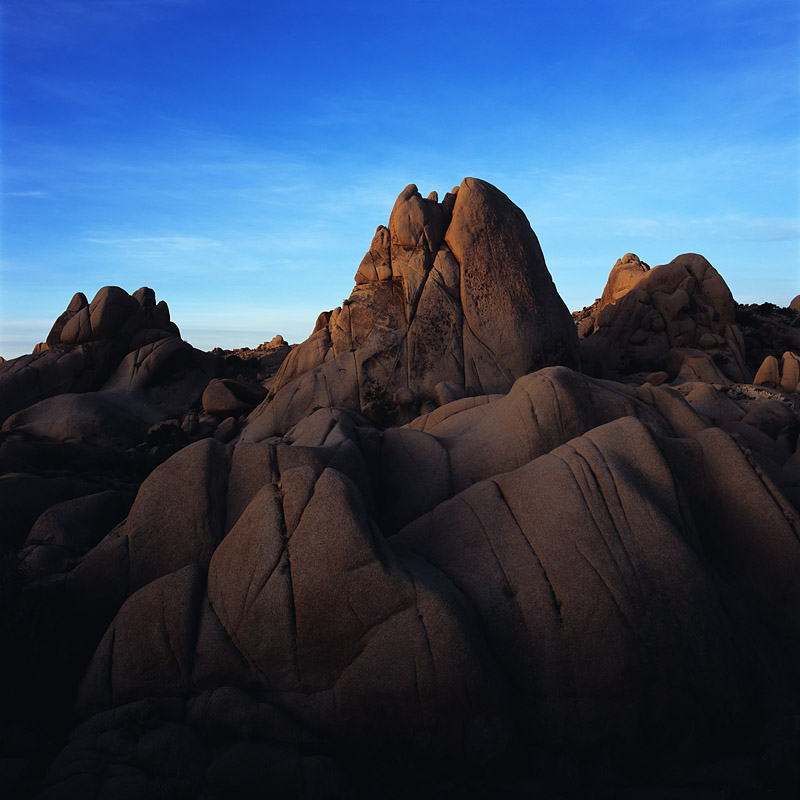 While the morning light illuminates the highest portion of these granite rocks, the light trails off into shadows in the deeper...